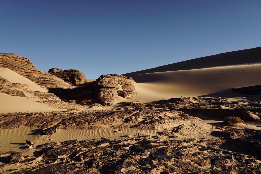 a desert landscape with rocks and sand dunes